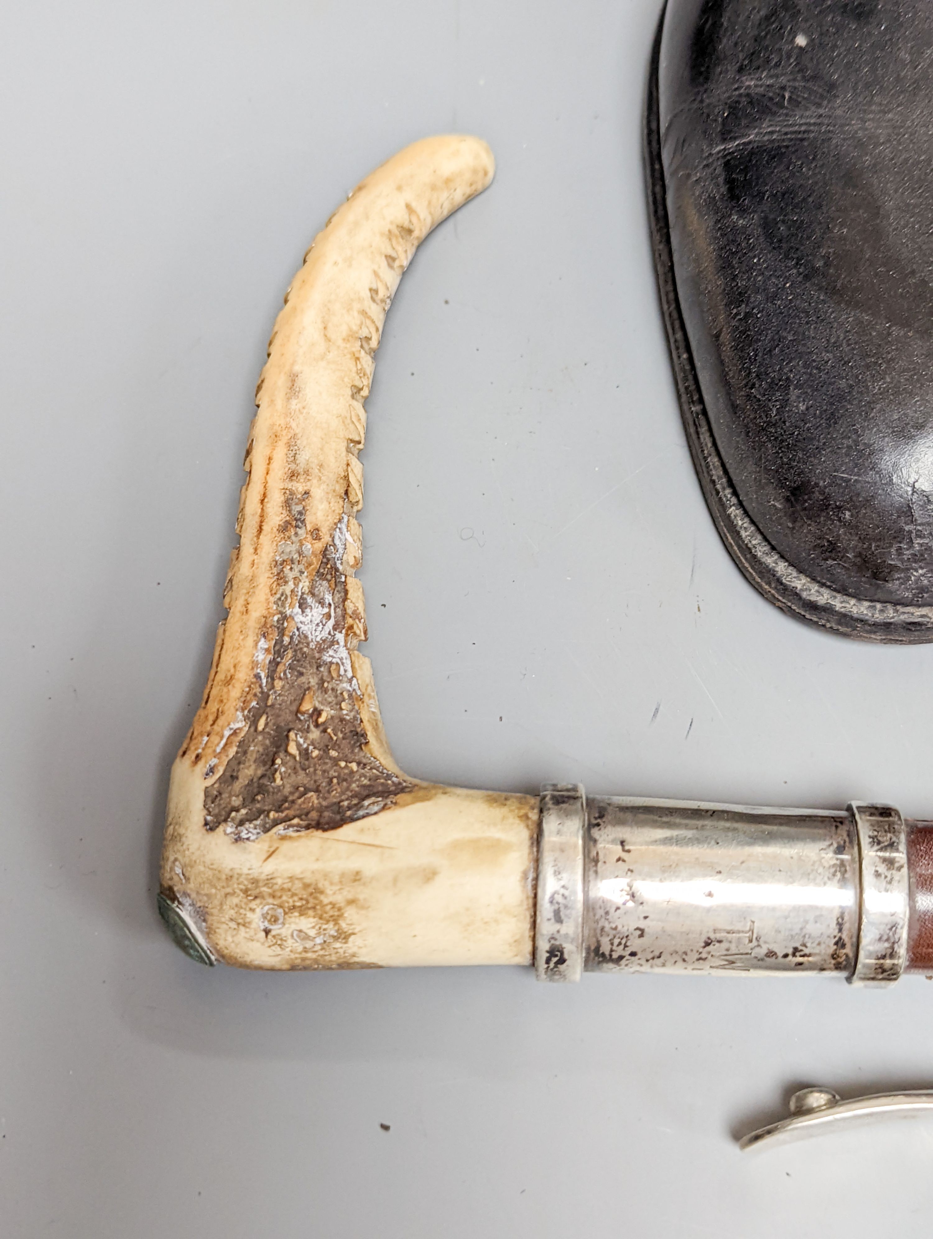 A pair of black leather riding boots with trees, a silver mounted whip and spurs